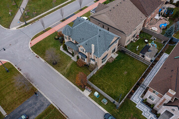 Suburban neighborhood showcasing detached residential houses with well maintained lawns and paved streets, representing real estate development and modern living in a planned community