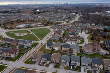 Suburban houses line winding streets around a community park and pond, emphasizing residential development and neighborhood planning on cannington crescent in brampton, ontario