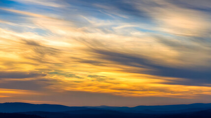 Fototapeta premium wholeness. Golden sunrise over a calm horizon, first light on clouds, serene landscape with deep blue sky. travel magazines, destination branding, designed for outdoor magazines and nature guides.