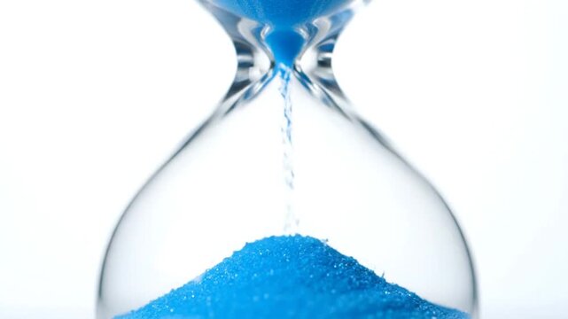 An antique sandglass with flowing sand on a blue background serves as a symbolic instrument for measuring time and business deadlines during a countdown
