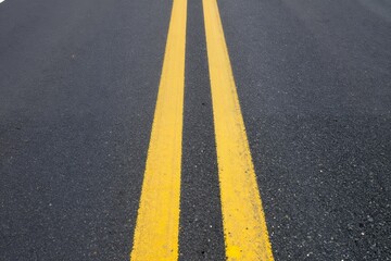 Double yellow lines on asphalt road close-up traffic markings