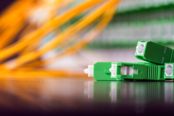 Close-up of an optical fiber distribution panel with connected patch cords and SC APC connectors during installation in a passive fiber optic network