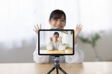 Young Woman Live Streaming with Tablet and Smiling at Camera