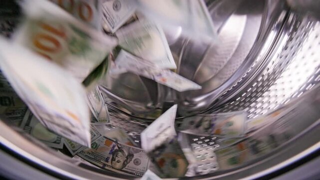 Hundred United States Dollar banknotes are spinning inside washing machine - for money laundering and fraud concept.