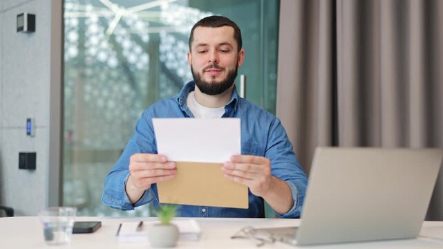 Man receives and reads an important letter, experiencing surprise, then excitement, and ultimately happiness from the good news it contains. A moment of career satisfaction and achievement.