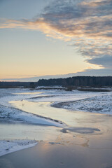 Landscape: ice on the river with reflections in the evening
