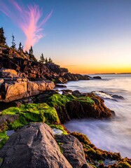Rugged coastline with mossy rocks meeting the ocean at dusk, colorful sunset sky
