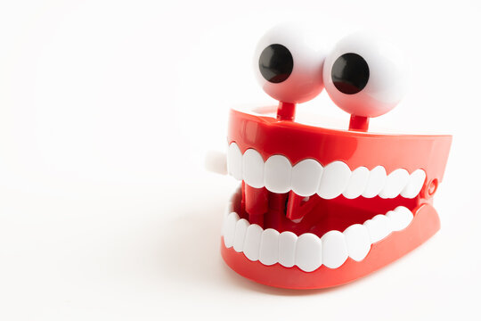 Tooth funny toy denture red color jaw and eye on white background with copy space.