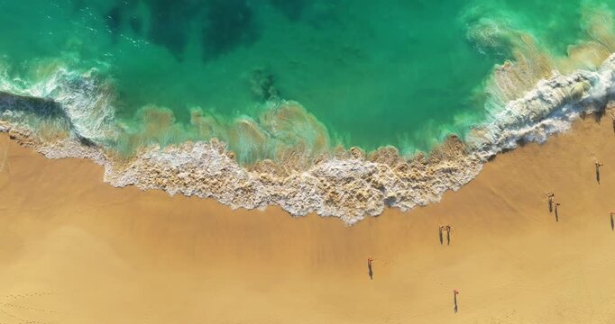 Aerial view waves break on white sand beach. Sea waves on the beautiful beach aerial view drone 4k shot. Beautiful of sea water wave come to beach.
