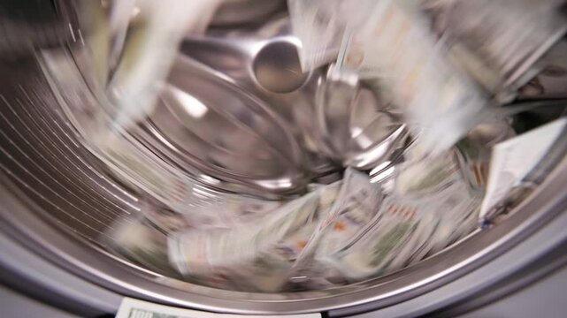 United States Paper Dollars spinning inside a washing machine, slo-mo wide angle closeup. Real life video.