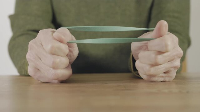 Stretching a green elastic rubber band