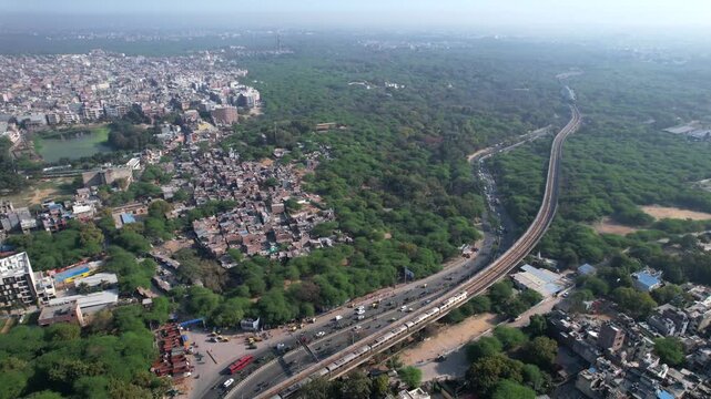 Aerial view of Delhi Metro with road traffic at Chhatarpur Metro Station, New Delhi, India