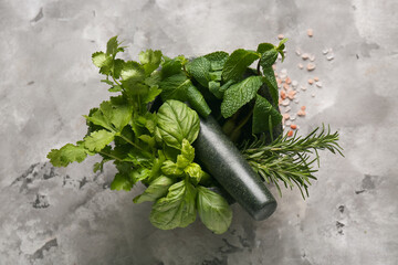 Mortar with different herbs and pestle on grey background © Pixel-Shot