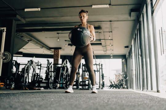 Athlete woman exercise together with dog at the gym.  Workout and indoor sport.