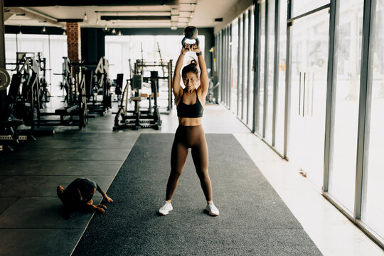 Athlete woman exercise together with dog at the gym.  Workout and indoor sport.
