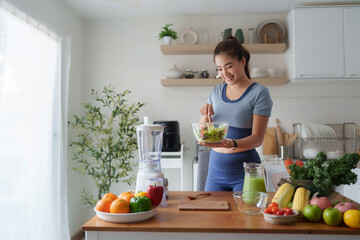 Young woman preparing fresh healthy salad in kitchen