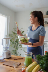 Woman smiling while preparing fresh healthy salad