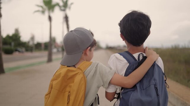 Two boys with backpacks walking on a boardwalk, one boy putting an arm around the other's shoulder, symbolizing friendship, support, and childhood adventure