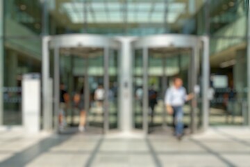 People's through the turnstiles entrance the mall. Blurry images