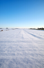 A farm field covered with snow in winter.