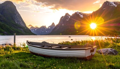 A boat rests on grassy shore, framed by mountains and a glowing sunset reflecting in the still water