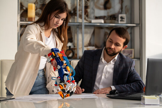 girl and man working with hydraulic robotic arm. STEAM education