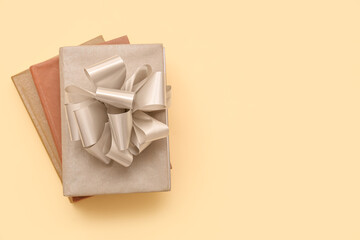 Stack of books with silver bow on yellow background