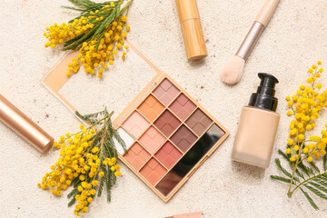 Naklejka premium Decorative cosmetics and mimosa flowers on white background