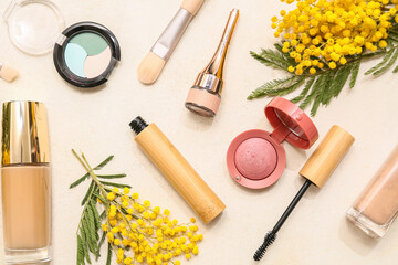 Naklejka premium Decorative cosmetics and mimosa flowers on white background