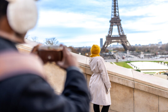 Couple traveling in paris photographing eiffel tower landmark