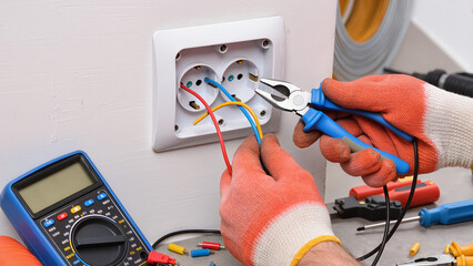 electrician installing electrical outlet