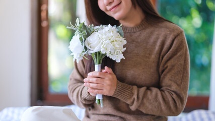 Closeup image of a woman holding a white flower bouquet