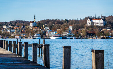 wooden pier with mountains in the distance, reflecting on calm water in the early morning light