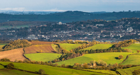 Obraz premium Long distance telephoto shot of Exmoor National Park from the outskirts of Dartmoor National Park with the city of Exeter in between showing two seasons in one day.