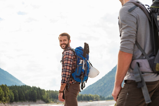 Brothers hiking outdoors in the mountains with backpacks on a summer day