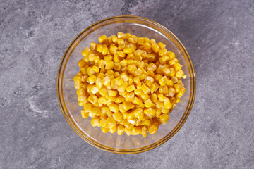 Boiled canned corn in a bowl on the table.