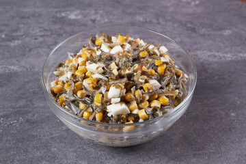 Seaweed, egg and corn salad with mayonnaise in a bowl on the table.