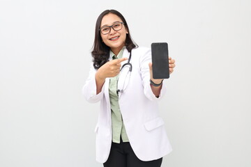 Asian female doctor smiling, standing wearing a doctor's coat, hanging a stethoscope around her neck, pointing to a blank phone screen, showing an app, online consultation, health advertisement.