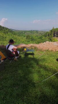 Asian women camping alone with mountain view. Solo outdoor activity and journey lifestyle on holiday.