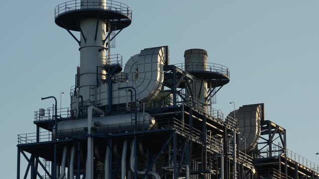 Close-up of complex pipework and ducts at a modern industrial facility.