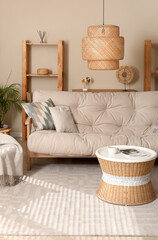 Interior of living room with comfortable sofa, coffee table, armchair and lamp