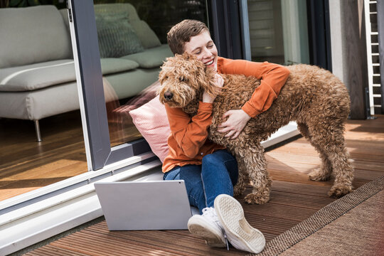 Woman working from home enjoying time with her dog indoors