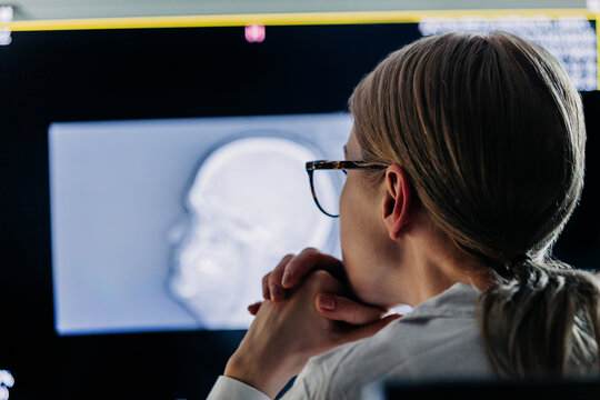 Doctor analyzing brain CT scan on monitor in hospital