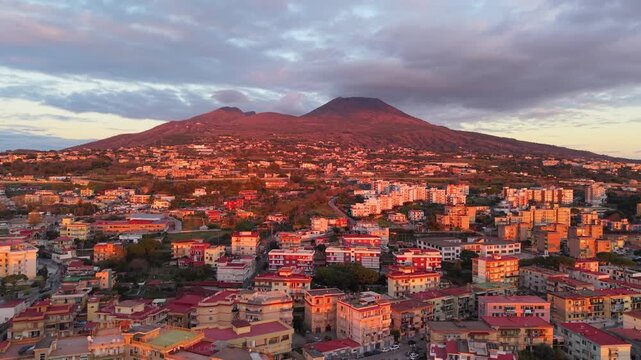 Drone footage of Mount Vesuvius at sunset, capturing the dramatic volcano, surrounding landscape, and warm golden light. Aerial view highlighting the iconic Italian landmark.