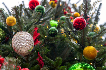 The Christmas tree on the city street is decorated with colorful toys. Christmas colorful ornaments. . High quality photo