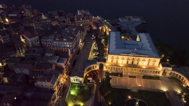Aerial Drone Flies Over the Illuminated Palace of St. Michael and St. George in Corfu Old Town at Night