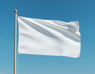 A white flag waving on a pole against a clear blue sky, viewed from a low angle.