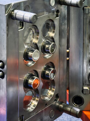 Close view of metal mold used for manufacturing plastic parts in an industrial setting during daytime