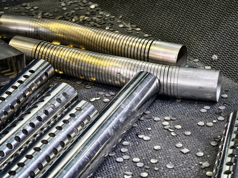 Metal rods and metal pieces on a factory floor during a production process in an industrial workshop