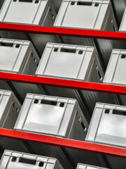 Storage containers arranged neatly on shelves in a warehouse setting for efficient organization and retrieval of items